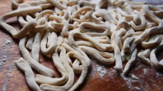 スペルト小麦粉で作った手打ちうどんの生地。木の台の上で打ち粉をふって乾燥中の様子。