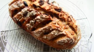 スペルト粒入りの古代小麦ノアレザン。クラストは香ばしく、クープからレーズンとくるみが覗くハード系パンのアップ写真